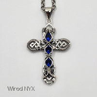 Blue Spinel (Lab Created) Wire Wrapped Cross Pendant in Sterling Silver (Oxidized) Material: Sterling Silver (Oxidized) Stones: Blue Spinel (Lab Created) Pendant height: 36mm Pendant width: 23mm Chain: Stainless Steel Round Rolo Chain (3mm) ~ Choose Length 18"-30" Inches