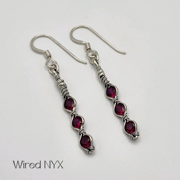 Lab Created Ruby Earrings Wire Wrapped in Sterling Silver (Oxidized) Material: Sterling Silver (Oxidized) Stones: Lab Created Ruby Earring length: 51mm