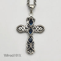Natural Blue Topaz Gemstone Wire Wrapped Cross Pendant in Sterling Silver (Oxidized) Material: Sterling Silver (Oxidized) Stones: Natural Blue Topaz Pendant height: 36mm Pendant width: 23mm Chain: Stainless Steel Round Rolo Chain (3mm) ~ Choose Length 18"-30" Inches